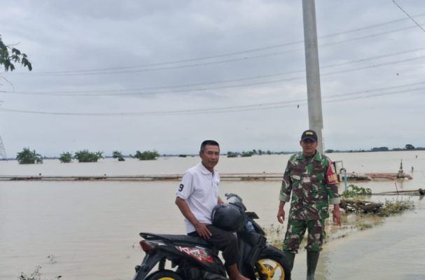 Babinsa Koramil 1611 Losarang Laksanakan Monitoring Luapan Air Jalan Puk Muntur -Ranjeng